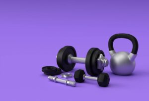 Assorted gym equipment including dumbbells and a kettlebell on a purple background.